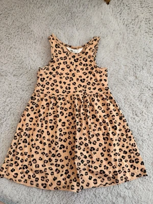 Leopardmönstrad ärmlös klänning - Ärmlös klänning i storlek 98/104 med leopardmönster i beige och svart. Jag samfraktar gärna för billigare frakt 💕 Kika in min profil för fler fynd! Öppen för prisförslag ✨
