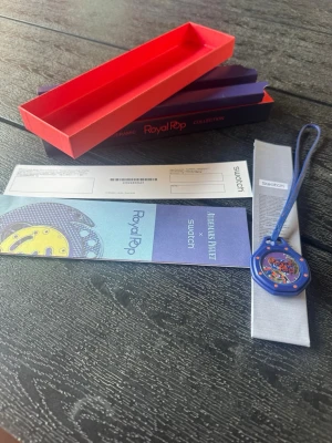 Blå Swatch Royal Pop klocka - Unik blå klocka från Swatch Royal Pop Collection med coolt transparent urtavla och färgglada detaljer. Klockan har ett blått band som kan bäras runt handleden eller hängas på väskan. Levereras med originalförpackning och tillbehör. Obs kop1a‼️