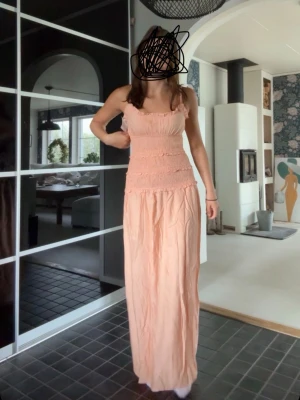 Ljusrosa långklänning med volang - Förlåt för dåliga bilder om man vill se mer så sök på frill detail dress på Nelly så hittar man! Detta är en helt Underbar sommarklänning med resorer längs vägen till midjan så klänningen får en volang effekt! Så vacker klänning och den är använd en gång och de va på 9an bal! NYPRIS 699:-