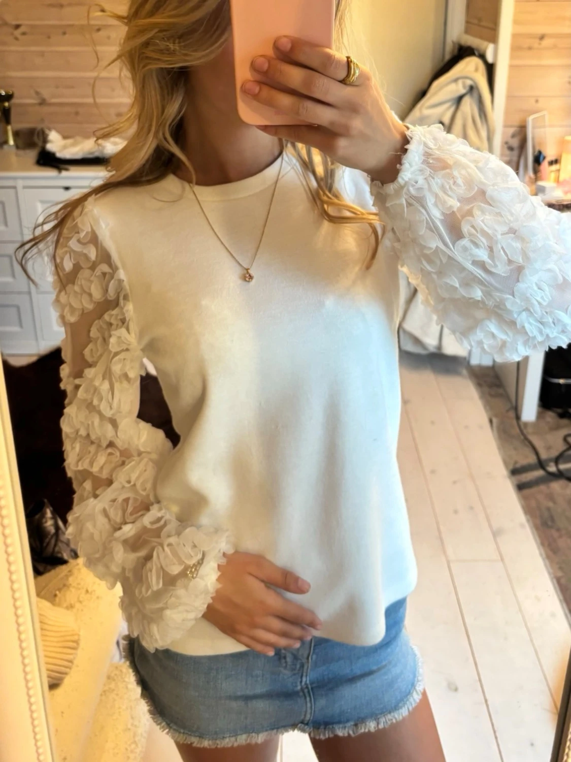 Vit blus med transparenta blommiga ärmar