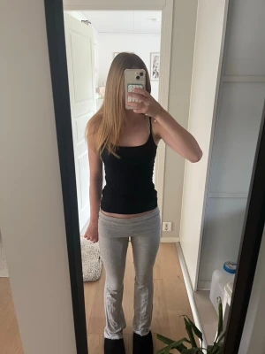 Grå ribbade leggings med utsvängda ben - Säljer ett par ljusgrå leggings med ribbad struktur och utsvängda ben. De har hög midja och sitter tight över höfterna. Perfekta för en avslappnad och trendig look. Materialet är mjukt och stretchigt för maximal komfort.
