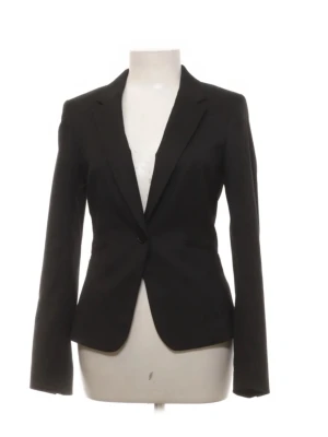 Svart figursydd kavaj - Stilren svart kavaj med figurnära passform och klassisk krage. Kavajen har en knapp framtill och långa ärmar. Perfekt för en snygg och uppklädd look. Materialet ser ut att vara en slät textil som ger en elegant känsla.