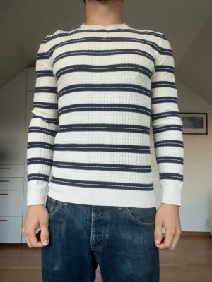 Vit stickad tröja med marinblå ränder - Stickad tröja från Esprit. Tröjan är tillverkad i 100% bomull. Strl S. Inga defekter. Modellen är 178 cm och väger 77 kg. Hör gärna av dig vid frågor!