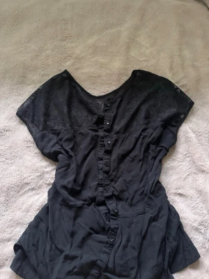 Svart blus med spets  - Snygg svart blus med spetsdetaljer. Från ginatricot storlek S