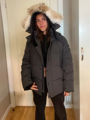 Svart pufferjacka med fuskpäls - Säljer min brors gamla Canada goose med stor huva och fuskpälsdetalj. Köptes förra vintern. Perfekt för kalla vinterdagar tack vare den tjocka vadderingen och den skyddande huvan. Öppen för prisdiskutering vid snabb affär