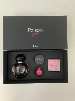 Dior Poison Girl presentbox parfym 30ml + 2 stämplar  - Lyxig presentbox från Dior med Poison Girl parfym. Innehåller en elegant mörk glasflaska, samt matchande accessoarer i svart och rosa. Boxen har stilren svart design med rosa och vita detaljer. Perfekt för dig som gillar exklusiva dofter och snygg förpackning. 30ml + 2 stämplar 