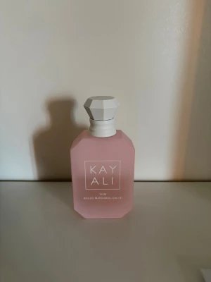 Kayali Yum Eau de Parfum ca 25 ml kvar  - Kayali Yum Eau de Parfum kommer i en matt, ljusrosa flaska med vit, diamantformad kork. Doften har noter av fresia, jordgubb, rosa marshmallow, krämig kokos, vispad vanilj och rosa mysk. Flaskan har en modern, stilren design som känns lyxig och trendig. Ca 25 ml kvar (50 ml flaska)