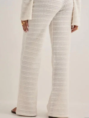 Vita virkade loungewear-byxor - Mysiga vita virkade loungewear-byxor med rak passform och hög midja. Byxorna har ett luftigt och mjukt material som passar perfekt för avslappnade dagar hemma. Det virkade mönstret ger en trendig och avslappnad look.