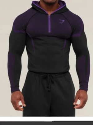 Svart och lila hoodie från Gymshark - Snygg svart hoodie från Gymshark med lila detaljer och halv dragkedja framtill. Tight passform och sportig design med huva och diskret Gymshark-logga på bröstet. Perfekt för gymmet. Materialet är stretchigt och andas bra. Helt ny! Kvitto finns. 