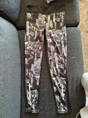 Svarta leggings med stadsmotiv - Snygga svarta leggings från mywear ACTIVE med coolt stadsmotiv i vitt och grått. De har bred midjeresår och är tillverkade i stretchigt material som passar perfekt för träning eller chill. Mönstret ger en urban vibe och de sitter tajt längs benen. Skriv privat för fler bilder eller om du har några frågor💗