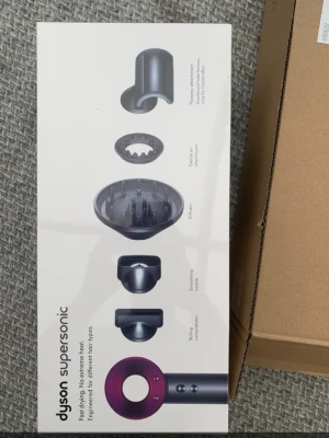 Dyson Supersonic hårfön - Säljer en Dyson Supersonic hårfön i snygg design med flera tillbehör som stylingmunstycke, diffuser, koncentrator och gentle air. Fönen är grå med lila detaljer och har avancerad teknologi för snabb och skonsam torkning av håret.