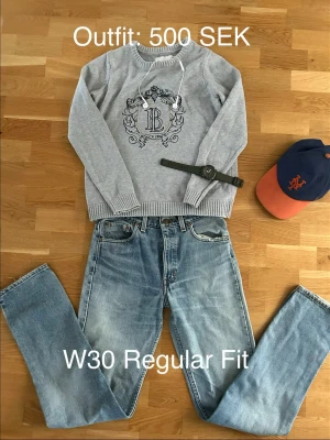 Levi Strauss & CO Regular Fit Jeans W30 - Säljer ett par ljusblå jeans i regular fit med klassisk femficksmodell och raka ben. Jeansen har en avslappnad tvättad look och passar perfekt till en casual stil. Materialet är denim i bomull och modellen har bälteshällor och knappgylf. Man kan köpa hela outfiten också eller bara tröjan.