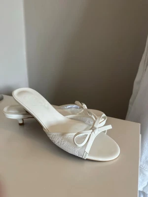 Vita pumps med rosett -  vita pumps med låg klack och öppen tå. Aldrig använda
