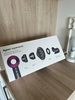 Dyson Supersonic hårfön - Dyson Supersonic hårfön i snygg grå och lila design. Kommer med fem olika stylingmunstycken för olika hårtyper, inklusive stylingkoncentrator, diffuser och mjukt munstycke. Innovativ form och material i hög kvalitet för snabb och skonsam hårtorkning.