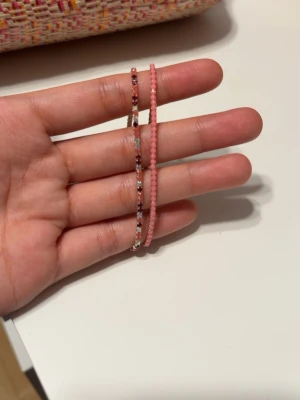 Färgglada pärlarmband i set - Säljer ett set med tunna armband gjorda av små pärlor i olika färger. Ett set går i rosa toner och det andra i grönt och blått. Perfekta för att mixa och matcha till din stil. Alla armband är elastiska och sitter bekvämt runt handleden. OBS!! 50kr per st 100 för en sett