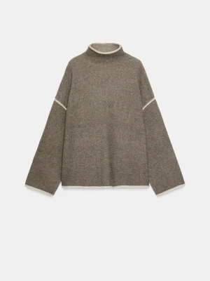 Brunmelerad stickad polotröja - Säljer en brunmelerad stickad polotröja med breda ärmar och kontrasterande vita detaljer vid hals, ärmslut och armbågar. Tröjan har en avslappnad passform och är perfekt för lager på lager. Materialet ser ut att vara mjukt och mysigt.