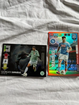 Två fotbollssamlarbilder - Säljer två fotbollssamlarbilder, en med Georgios Samaras från Celtic FC i grönvitrandig tröja och en limited edition-design, samt en färgglad Panini FIFA 365-kort med Kostas Manolas från Napoli i blå och vit matchställ. Perfekt för samlare!