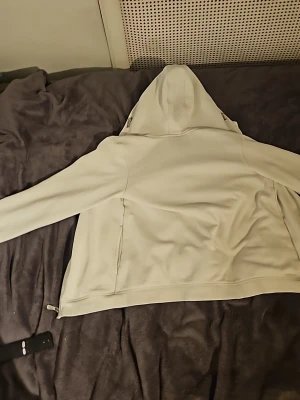 Ljus hoodie från Sail Racing - Säljer en ljus hoodie från Sail Racing i storlek 170. Hoodien har en klassisk huva, långa ärmar och dragkedja i sidan. Materialet är mjukt och fleece-liknande på insidan, perfekt för att hålla värmen. Enkel och stilren design som passar till det mesta.
