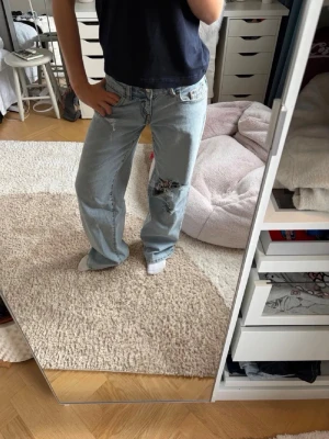 Low waist baggy jeans  - Säljer ett par ljusblå baggy jeans med slitningar och hål. Jeansen är helt nya sen har jag gjort hålen själv. Skriv vid frågor 