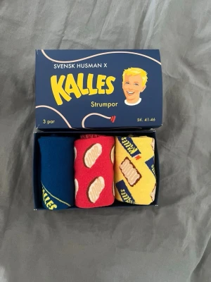 Kalles kaviar strumpor 3-pack - Roligt 3-pack strumpor i samarbete med Kalles kaviar och Svensk Husman. Innehåller ett par blå, ett par röda och ett par gula strumpor med olika kaviarmotiv och logga. Perfekt för dig som vill ha färgglada och unika strumpor med svensk twist . Oanvända!