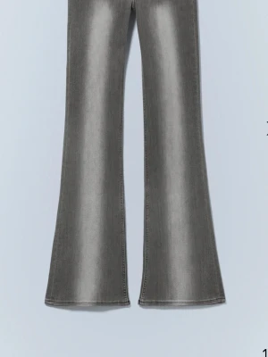 Gråa utsvängda jeans - Säljer ett par gråa jeans med utsvängda ben och låg midja. Från weekday i strl 28/30. Jag är ca 168 och de sitter lite över mina fötter. Slutsålda men nypris 399. 