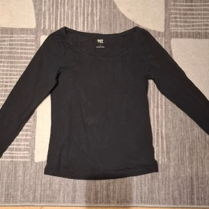 Svart långärmad topp - En enkel svart långärmad topp med rund halsringning. Perfekt basplagg som funkar till det mesta och är lätt att matcha med andra plagg. Tillverkad i mjukt material för en bekväm känsla.