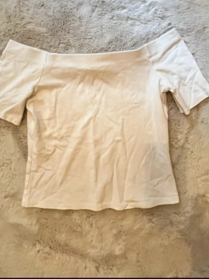Vit offshoulder topp -  vit offshoulder topp med korta ärmar och figurnära passform. Från hm i strl 38/M. Använd fåtal gånger!