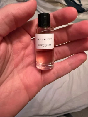 Spice Blend parfym från Dior 7,5ml - Exklusiv Spice Blend parfym från Christian Dior i en liten cylinderformad glasflaska med svart kork. Doften har en varm, kryddig karaktär och vätskan är ljus bärnstensfärgad. Perfekt för dig som gillar lyxiga och unika parfymer.