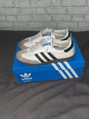 Adidas Samba vita och svarta sneakers - Klassiska Adidas Samba sneakers i vitt och svart med gråa detaljer. Säljer eftersom har köpt andra skor