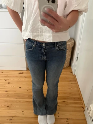Blå bootcut jeans med hög midja - Säljer ett par klassiska blå bootcut jeans med medelhög midja och femficksmodell. Jeansen har en snygg tvätt och är nästan aldrig använda☺️ De är uppsydda på ett snyggt och omärkbart vis som visas på sista bilden, innerbenslängden är 69cm🩷Använd gärna köp nu☺️
