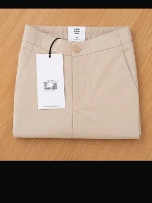 Beige shorts med fickor helt ny med etikett -strl 50 - Snygga beige shorts med klassisk passform och raka ben. De har sidofickor, midwaist och stängs med knapp och dragkedja. Perfekta för varma dagar och enkla att matcha med olika stilar. Helt ny med etikett. Ordinariepris: 800 kr.