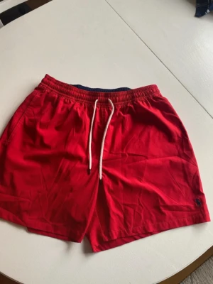 Röda badbyxor från Polo Ralph Lauren - Snygga röda badbyxor från Polo Ralph Lauren. Klassisk passform med logga broderad på benet. I nyskick. 