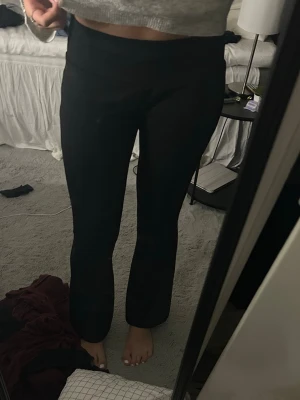 Svarta bootcut leggings - Säljer ett par svarta leggings med bootcut-modell. De är stretchiga och sitter tajt över låren men släpper ut lite vid vaden. Perfekta för en avslappnad och trendig look.