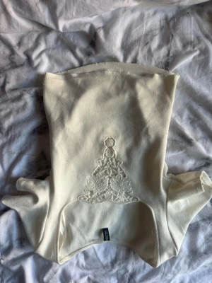 Vit bandeau tubtopp med spetsdetalj - Säljer en vit bandeau tubtopp med snygg spetsdetalj framtill. 