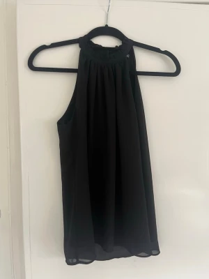Svart ärmlös topp från New Look - Säljer en svart, ärmlös topp från New Look med hög hals och lätt rynkad detalj vid halsringningen. Toppen har en luftig passform, och är i bra skick☺️