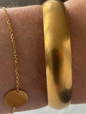 Armband guld - Matt Armband som jag tror det är överdrag med 18 k guld. Inköpt på NK bijouteri, Monet. Ca 1,5 cm brett. Är använt några gånger, syns spår av användning men inget som direkt stör.. One size, passar de flesta.
