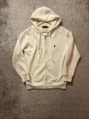 Ralph Lauren zip  - Säljer denna vita Ralph Lauren zip. Väldigt bra skick nästintill ny. Storleken är S passar ca (170-180) Skriv vid frågor eller möjligen byte!