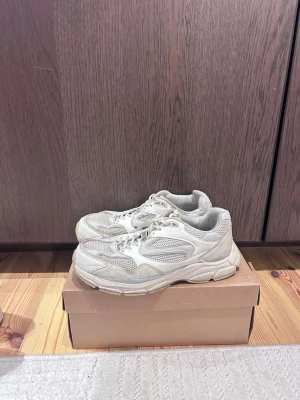 Beige  chunky sneakers med meshdetaljer - Säljer ett par vita chunky sneakers med meshdetaljer och snörning. Skorna har en sportig look med tjock sula och blandning av syntetmaterial och mesh för extra andningsförmåga. Perfekta för dig som gillar streetwear och vill ha bekväma sneakers till vardags.