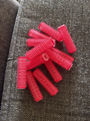 Röda hårrollar - Säljer ett gäng röda hårrollar i plast med kardborre. Perfekta för att fixa volym och lockar i håret. Cylindrisk form och lätta att använda, passar både kort och långt hår. Snygg retrostil och smidiga att ta med i väskan.