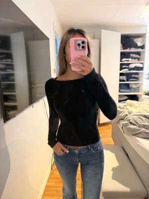 Svart långärmad topp  - Säljer en svart långärmad topp med figurnära passform och bred, båtringad urringning. Toppen är enkel men stilren och passar perfekt till jeans eller kjol. Perfekt för dig som gillar en clean och trendig look. Storlek Xs passar även S