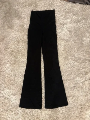 Svarta utsvängda leggings Gina Tricot - Säljer ett par svarta leggings från Gina Tricot i storlek XS. De har hög midja och utsvängda ben vilket ger en snygg siluett. Materialet är stretchigt och bekvämt, perfekt för en trendig och avslappnad look.