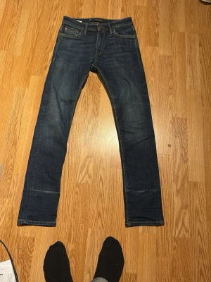 Mörkblå raka jeans - Snygga mörkblå jeans med raka ben och klassisk femficksdesign. Jeansen har kontrastsömmar och en läderpatch bak i midjan. Tillverkade i denim med en stilren look som passar till det mesta. Pris kan diskuteras 