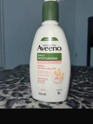 Aveeno Daily Moisturising Creamy Oil - Fuktgivande krämig olja från Aveeno i en vit plastflaska med grön pump. Innehåller havre och sötmandelolja, passar normal till torr hud. Flaskan rymmer 300 ml och har en enkel, stilren design.