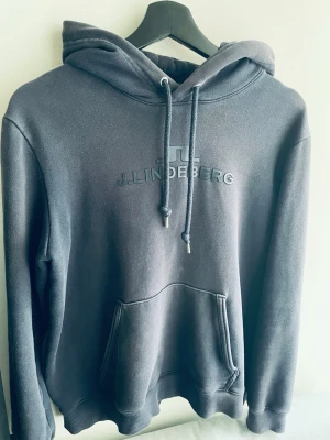 J.Lindberg Hoodie - Säljer en mörkblå J.Lindberg hoodie. Hoodien passar dig perfekt om du är mellan 170-175
