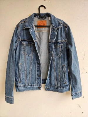 Levi's jeansjacka - Jeansjacka från Levi's i jättefint skick, knappt använd. Storlek M. En bröstficka och en sidoficka på varje sida.