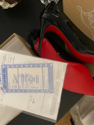 Svarta lackpumps med röd sula - Snygga svarta pumps i lack från Christian Louboutin med ikonisk röd sula och spetsig tå. Klackarna är höga och eleganta, perfekta för att lyfta vilken outfit som helst. Klassisk design med lyxig känsla och exklusiv finish.