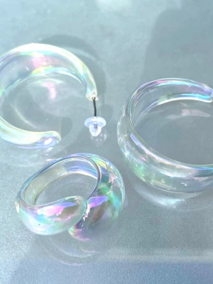 Iridescent chunky hoops och ring i akryl Y2K Aesthetic smyckeset  - Säljer ett par chunky örhängen och en ring i transparent akryl med iriserande effekt som skiftar i regnbågens färger. De har en rundad, tjock form och ger en futuristisk vibe. Perfekta för dig som vill sticka ut med accessoarer som fångar ljuset på ett coolt sätt.