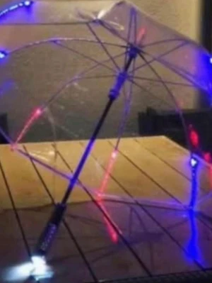 Transparent LED-paraply med färgat ljus - Säljer ett transparent paraply med inbyggda LED-lampor i blått och rött som lyser upp hela paraplyet. Paraplyet har svart handtag och är perfekt för att sticka ut i mörkret. Märkt med 'AllOfSweden.com' på kanten. Riktigt cool accessoar för regniga dagar.