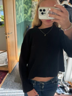 Svart stickad tröja - En svart, stickad tröja med långa ärmar och rund hals. Tröjan har en enkel och stilren design med ribbstickade muddar vid ärmslut och nederkant. Perfekt att matcha med jeans för en avslappnad look.💕