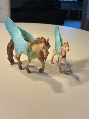 Pegasusfigurer med blå vingar - Två pegasusfigurer från Schleich, en större och en mindre. 